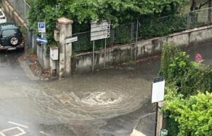 Tombino divelto in piazza San Guido, l’acqua allaga l’incrocio